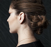 Black-and-white profile of a woman with a sleek, twisted low bun updo